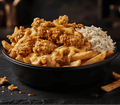 A black bowl filled with loaded fries topped with crispy fried chicken, melted cheese, and coleslaw, set on a dark slate plate with extra fries beside it.