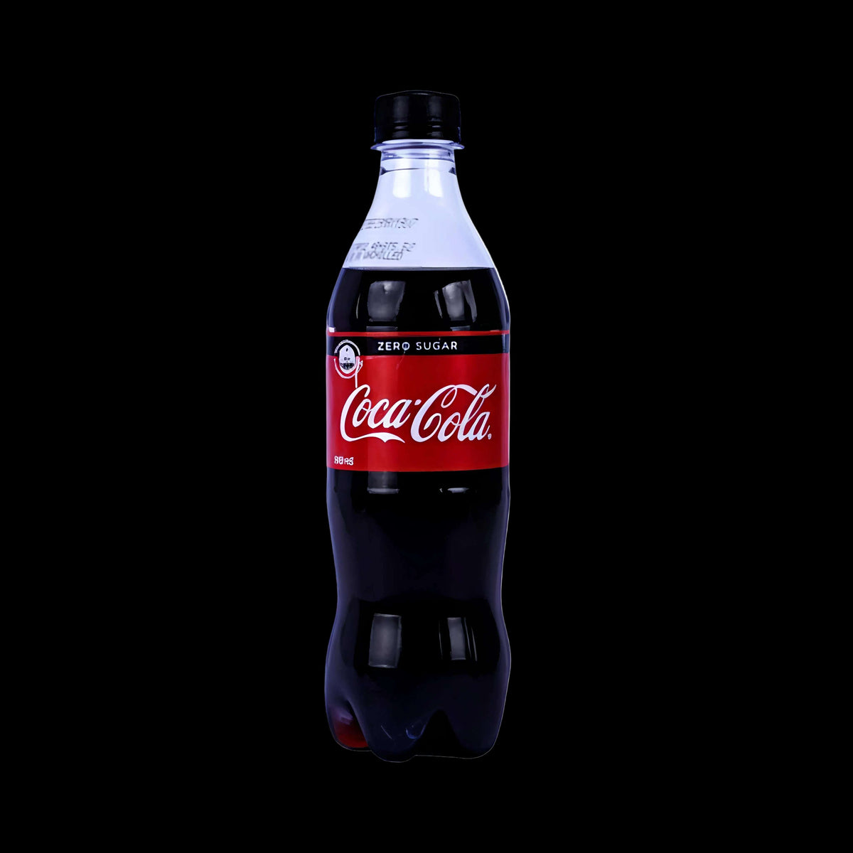 A 500 ml bottle of Coca-Cola Zero Sugar, showing the dark cola liquid and the classic red label with white script, on a plain white background.
